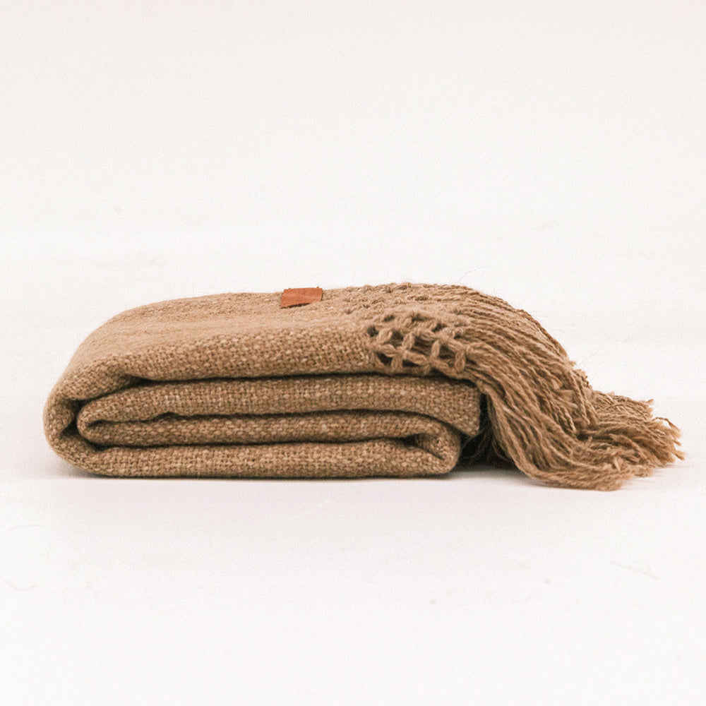 Folded brown blanket with a textured edge on a white background- Number 1