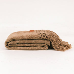 Folded brown blanket with a textured edge on a white background - Number 1