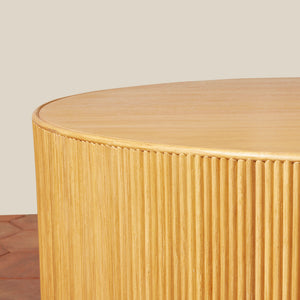 Round wooden side table with a ribbed texture on a neutral background - Number 11