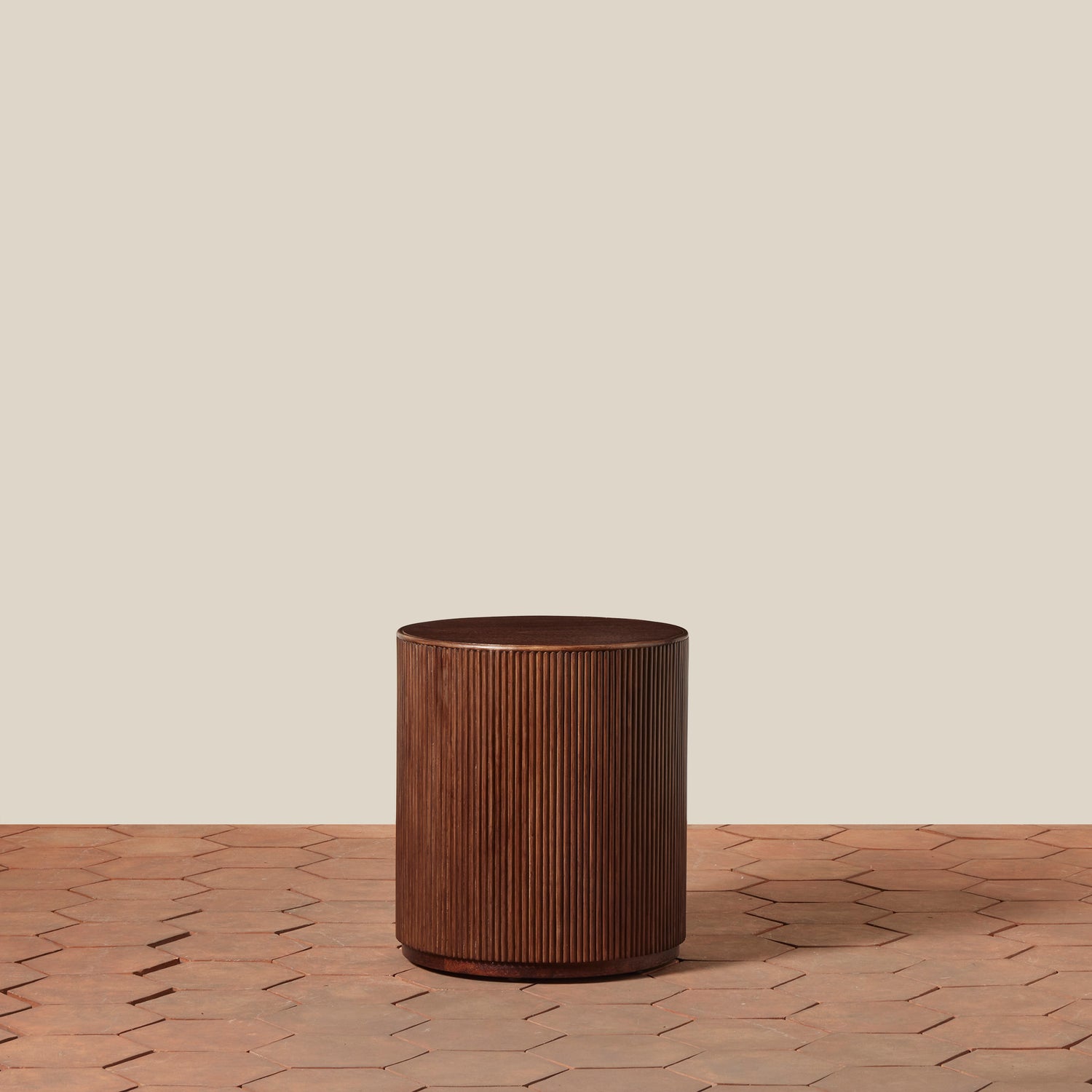 Wooden cylindrical side table on a wooden surface with a beige background- Number 1