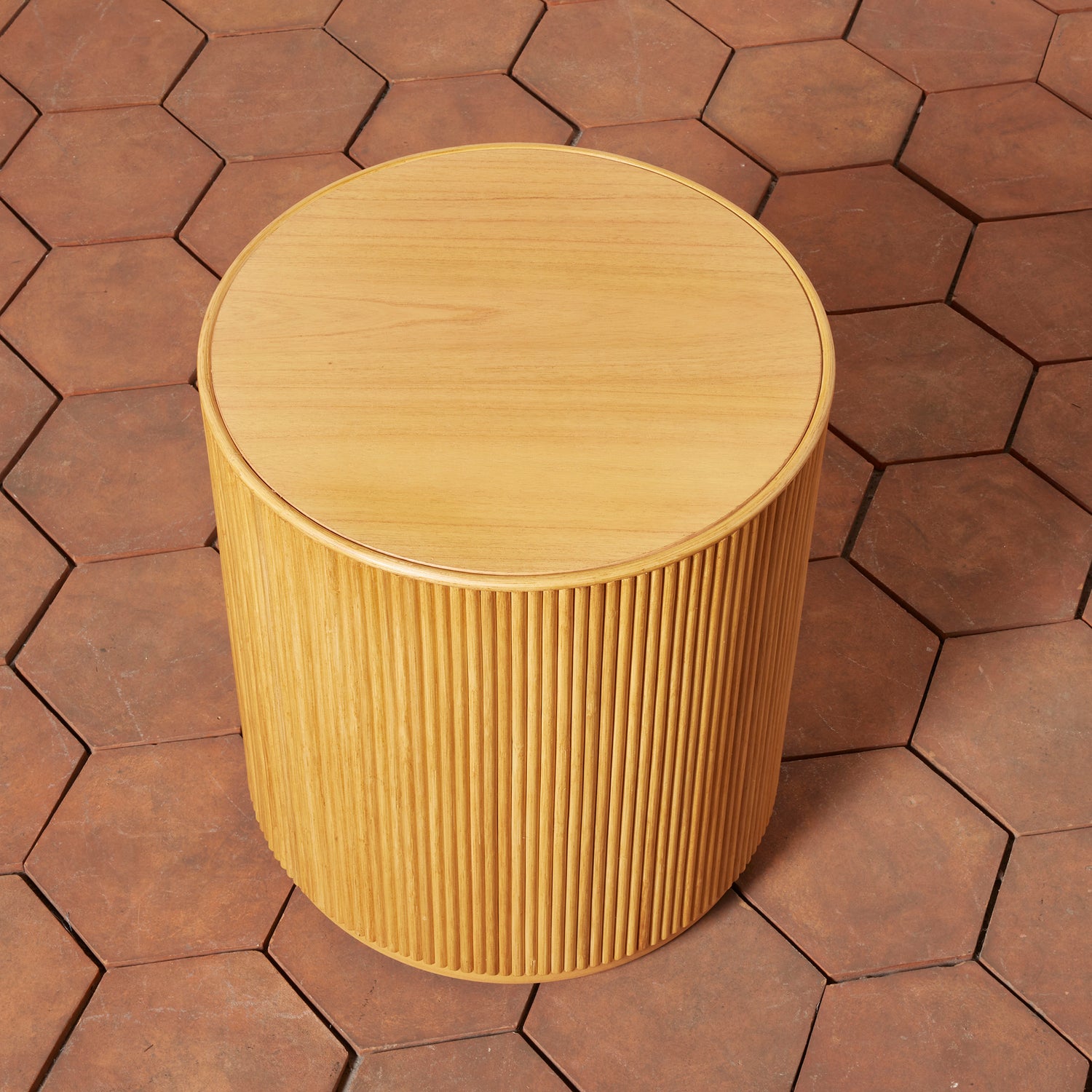 Wooden cylindrical stool on a hexagonal patterned pavement- Number 8