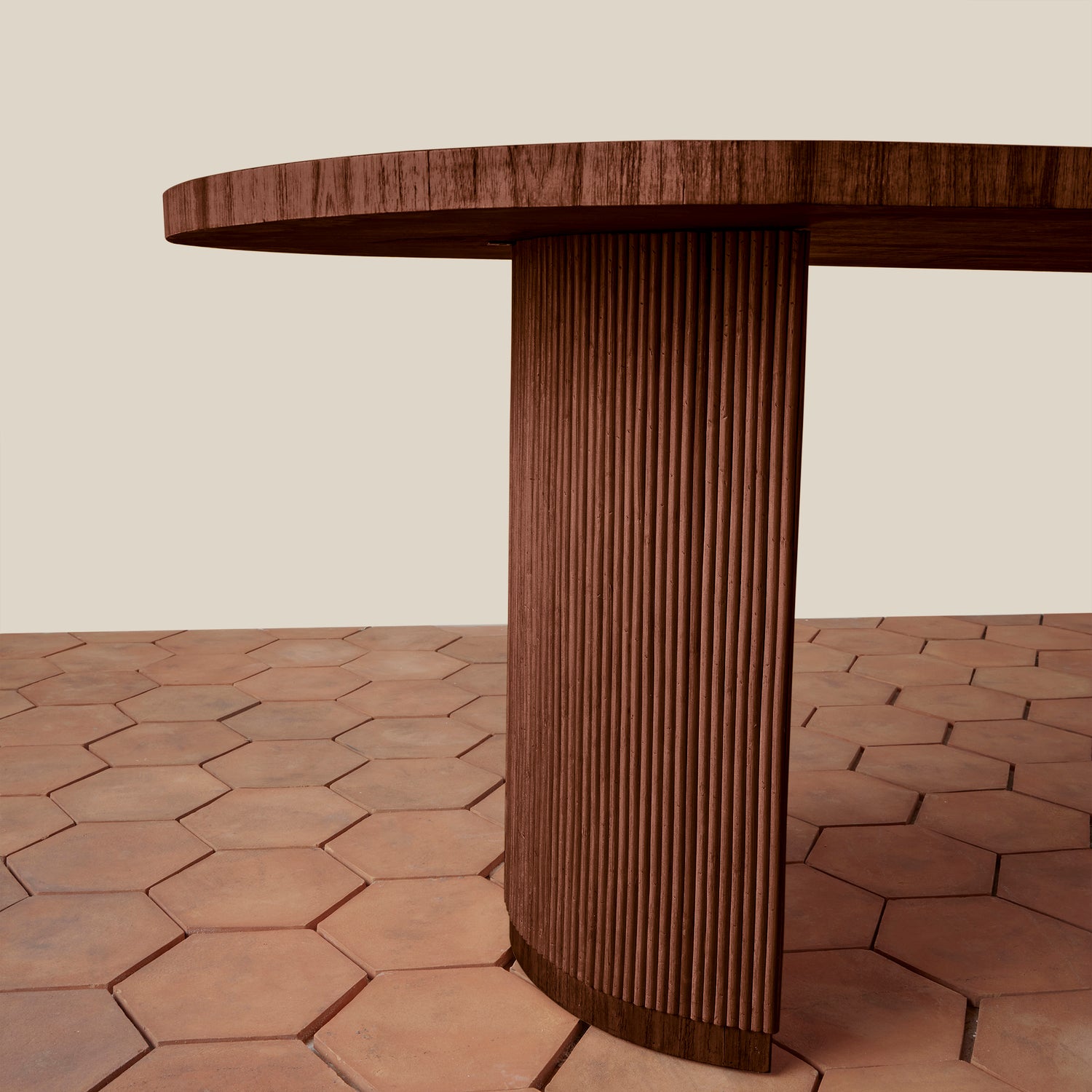 Wooden table with a textured cylindrical base on a hexagonal tile floor.- Number 3