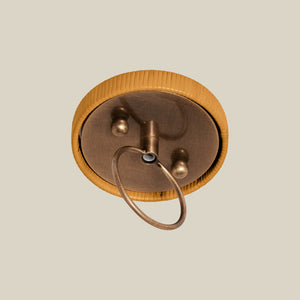 Bronze pendant against a beige background - Number 4