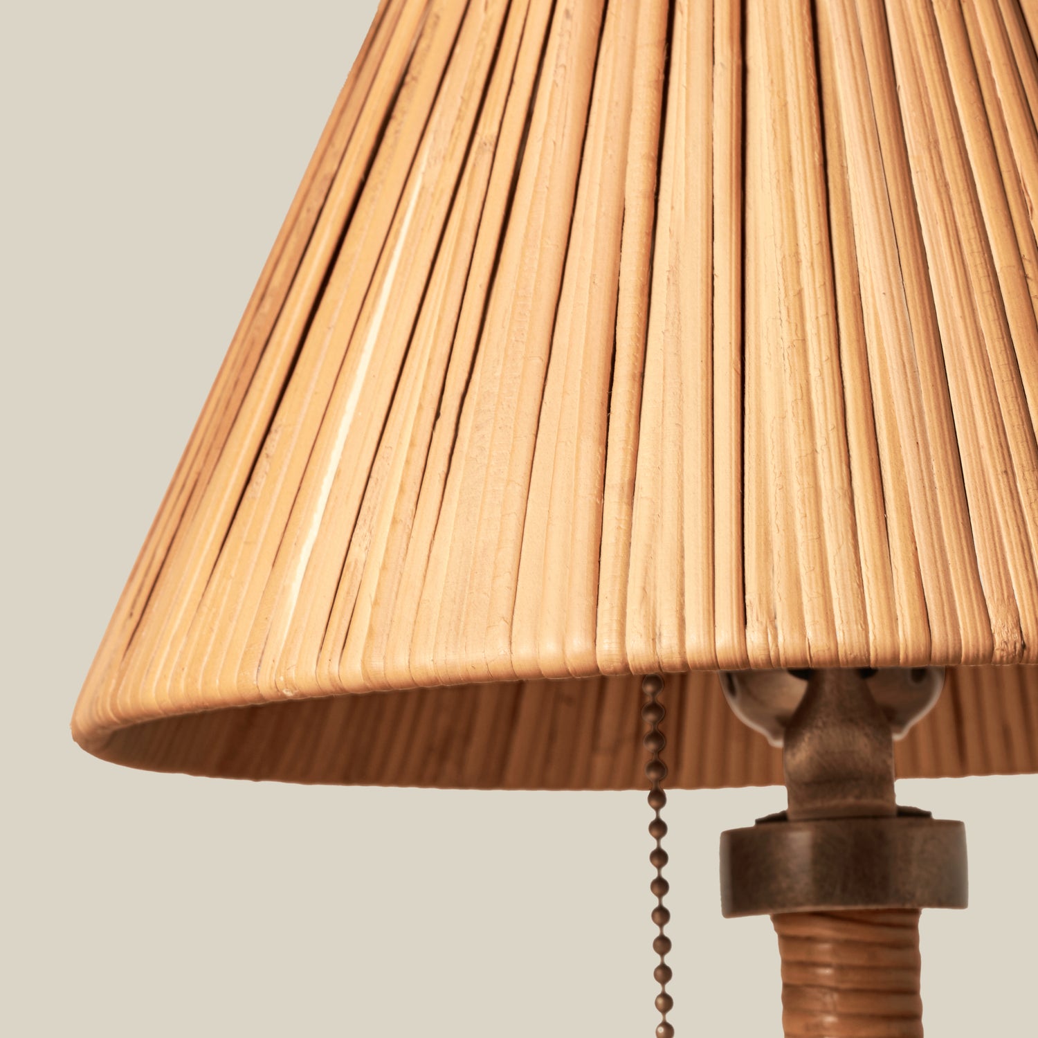 Small rattan table lamp with brass accents on wooden table against beige background- Number 6