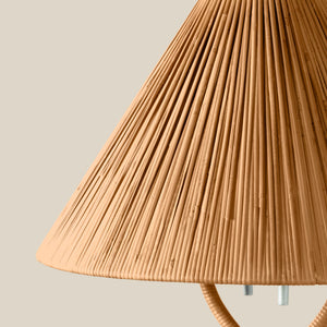 Close-up of a pleated conical lampshade in a warm natural tan color, with part of the lamp's cord and metal socket visible against a plain light beige background. - Number 3