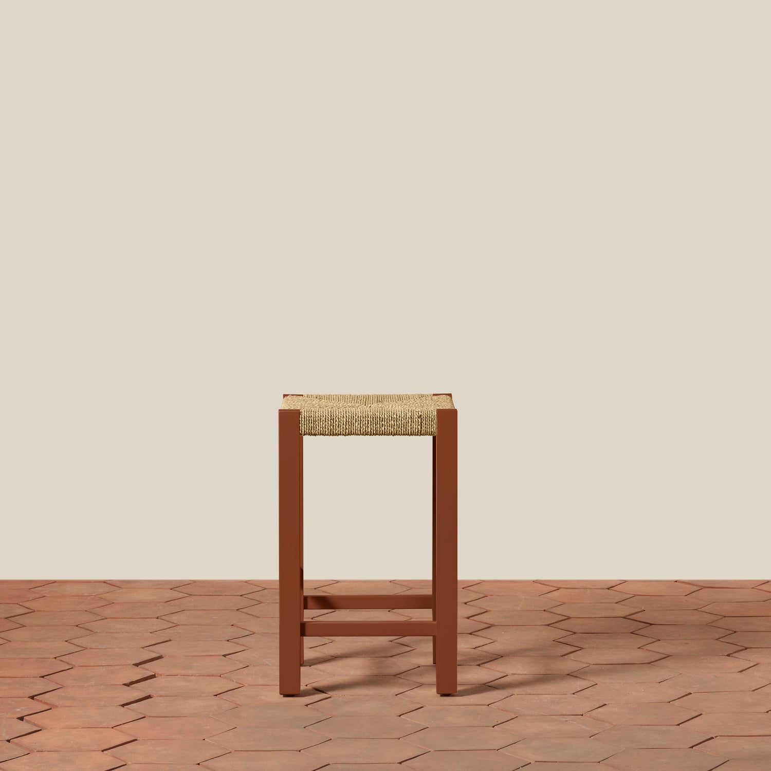 Wooden stool with woven seat on a wooden floor and beige wall background- Number 6