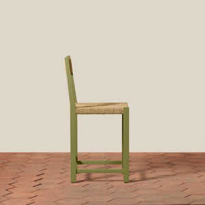 Green chair with woven seat on a wooden floor and beige wall background - Number 20