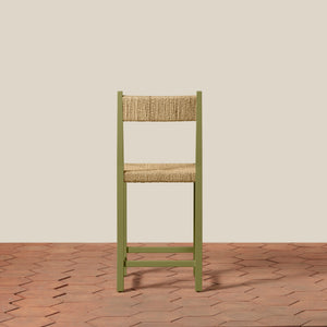 Green chair with woven backrest on a wooden floor and beige wall - Number 22