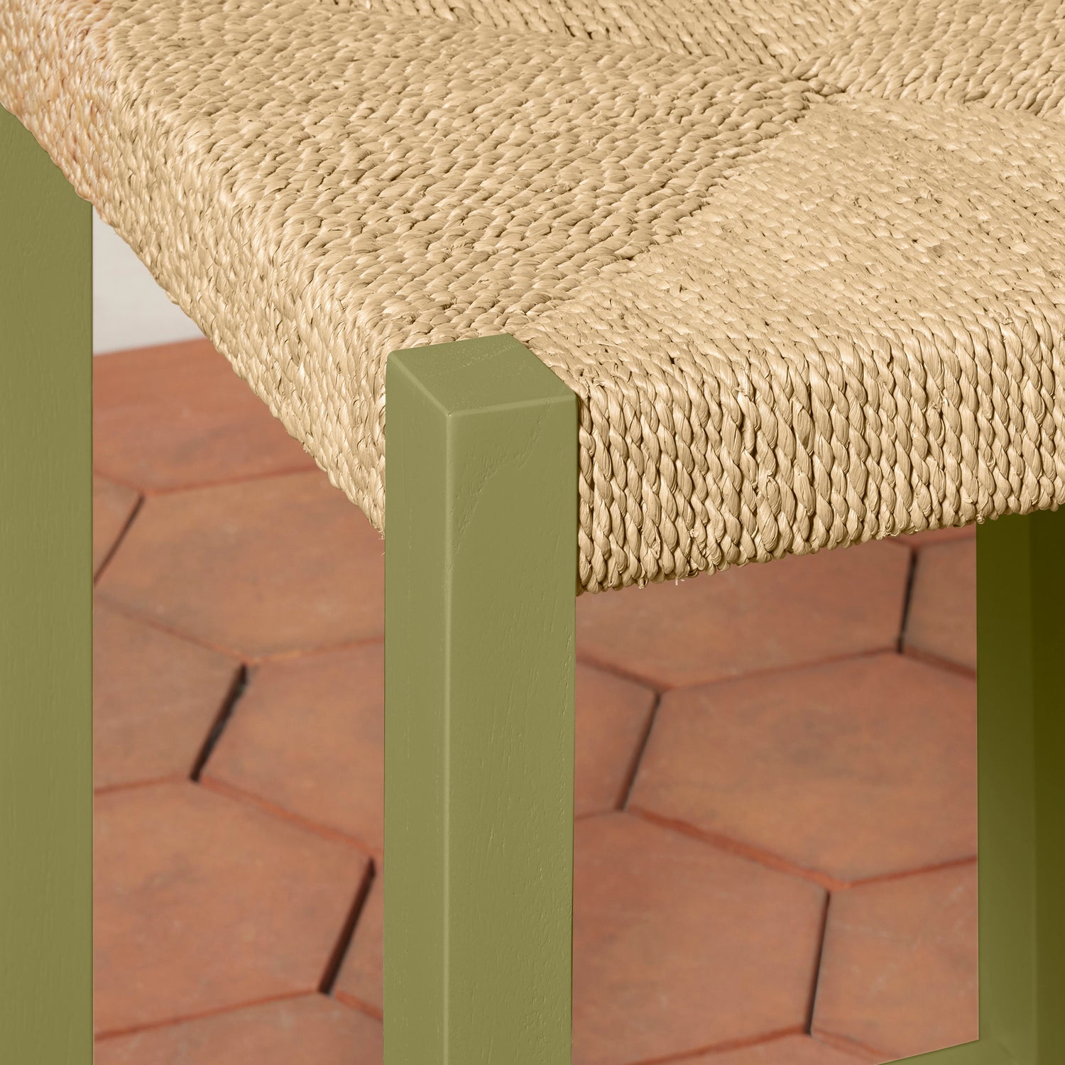 Close-up of a woven bench seat with a green frame on a brick surface- Number 24