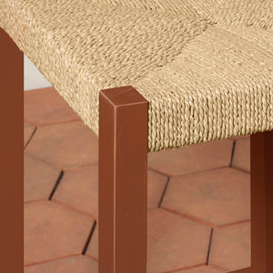 Close-up of a woven chair seat with a brown wooden frame on a brick surface. - Number 12