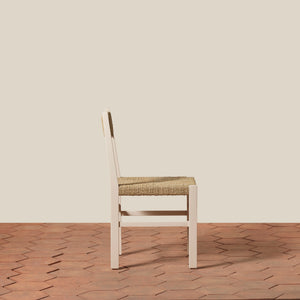 White chair with woven seat on a wooden floor and beige wall - Number 16