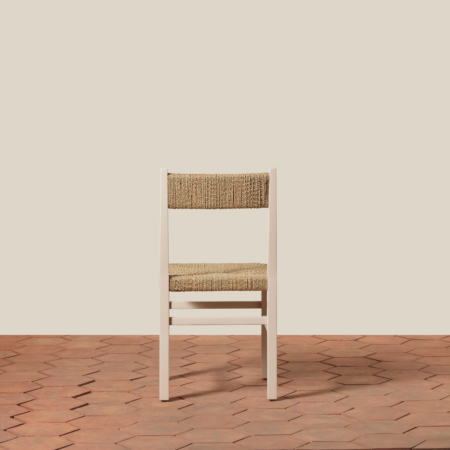 White chair with woven backrest on a wooden floor and beige wall- Number 18