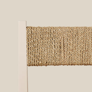 Close-up of a textured woven seat back on a light beige wall. - Number 19