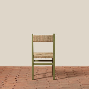 Green chair with woven seat on a wooden floor and beige wall background - Number 24