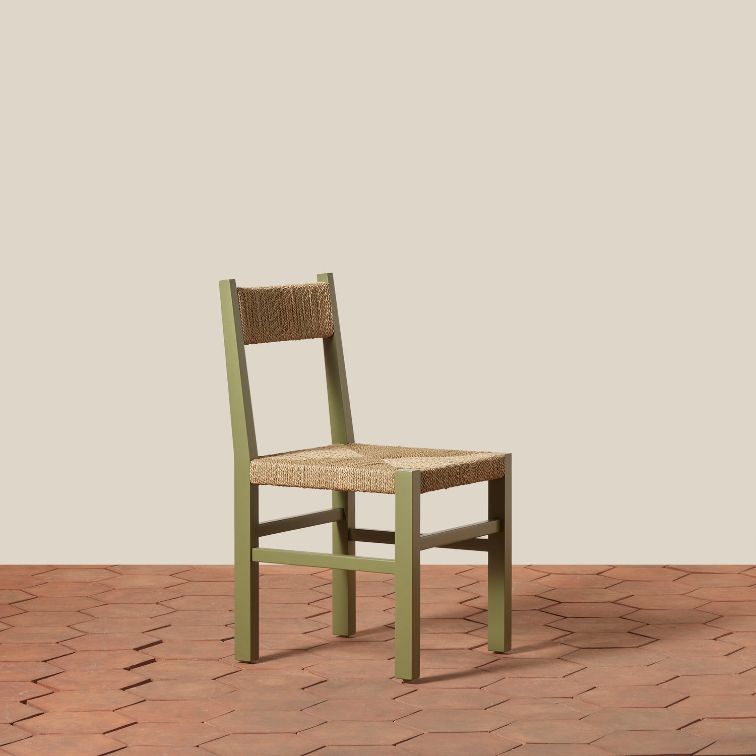 Green chair with woven seat on a wooden floor and beige wall background- Number 21