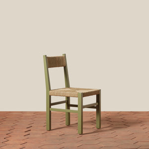 Green chair with woven seat on a wooden floor and beige wall background - Number 21