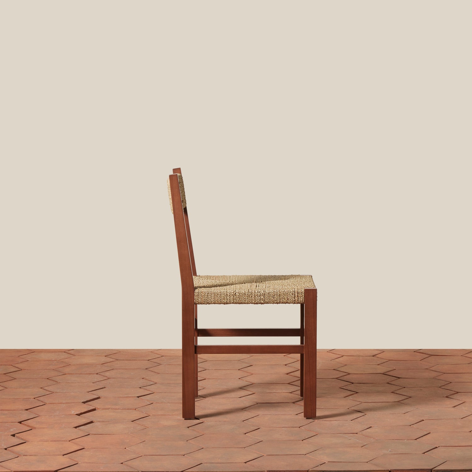 Wooden chair with woven seat on a wooden floor and beige wall background- Number 10