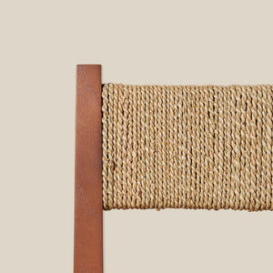 Close-up of a brown wooden chair frame with a textured woven back on a beige background - Number 13