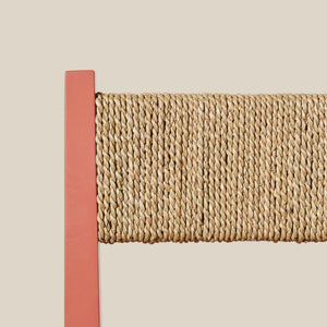 Close-up of a woven chair back with a pink border on a beige background - Number 7