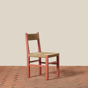 Wooden chair with woven seat on a wooden floor and beige wall background - Number 1