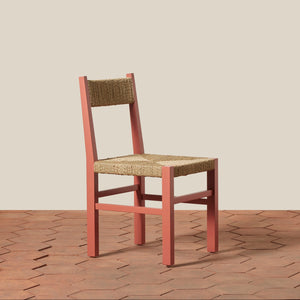 Wooden chair with woven seat on a wooden floor and beige wall background - Number 1