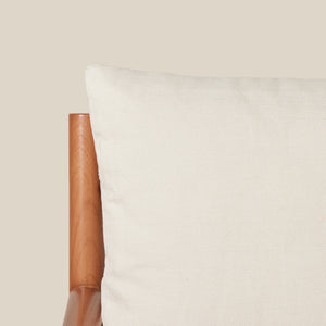 Close-up of a white pillow with a brown armrest on a neutral background - Number 11