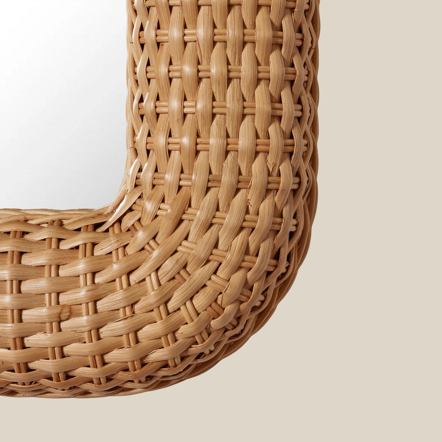 Close-up of a woven rattan mirror on a plain background- Number 3