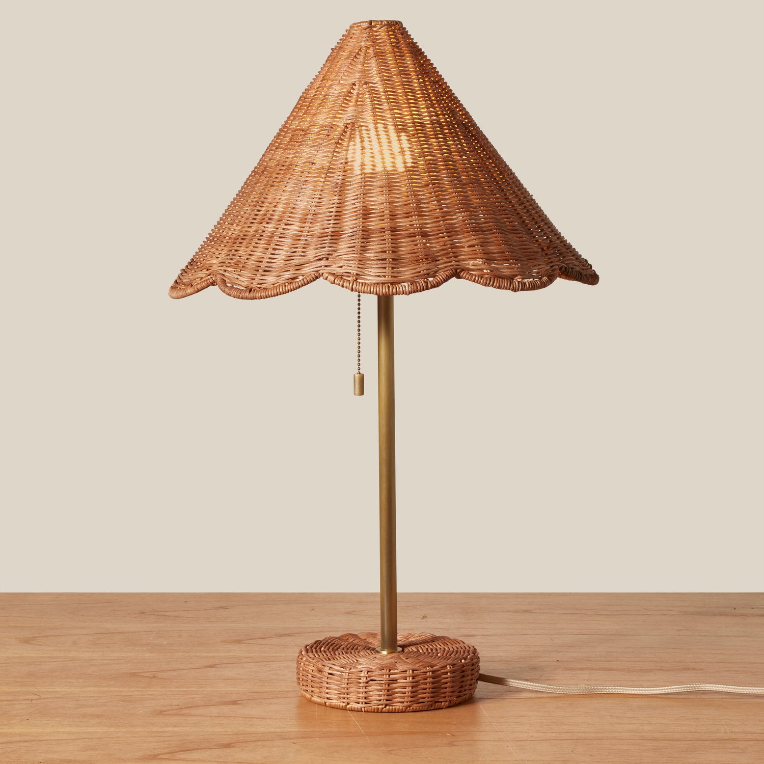 Wicker table lamp with a scalloped shade on a wooden surface.- Number 2