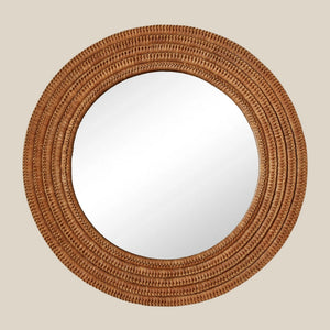 Round mirror with a woven brown frame on a beige wall - Number 1