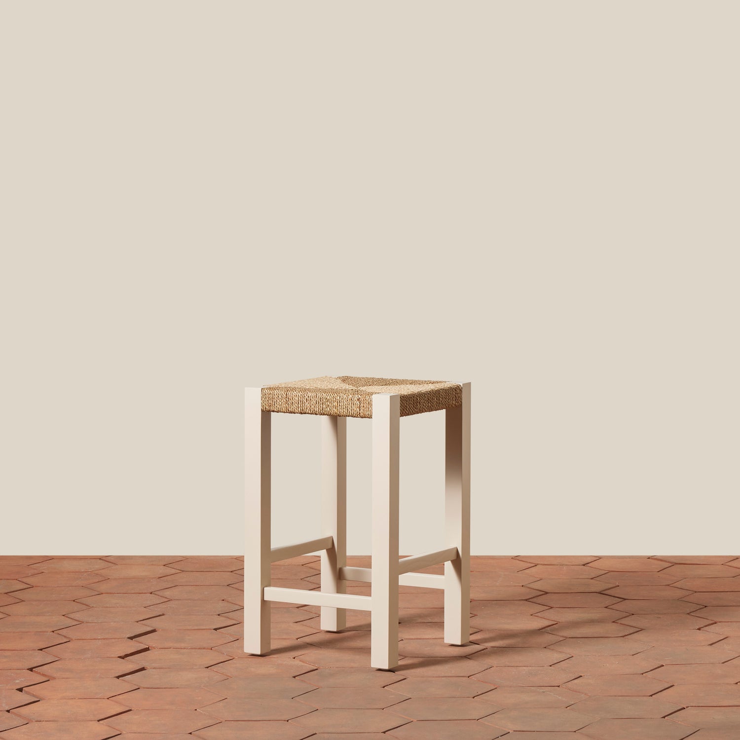 Wooden stool with woven seat on a wooden floor and beige wall background- Number 9