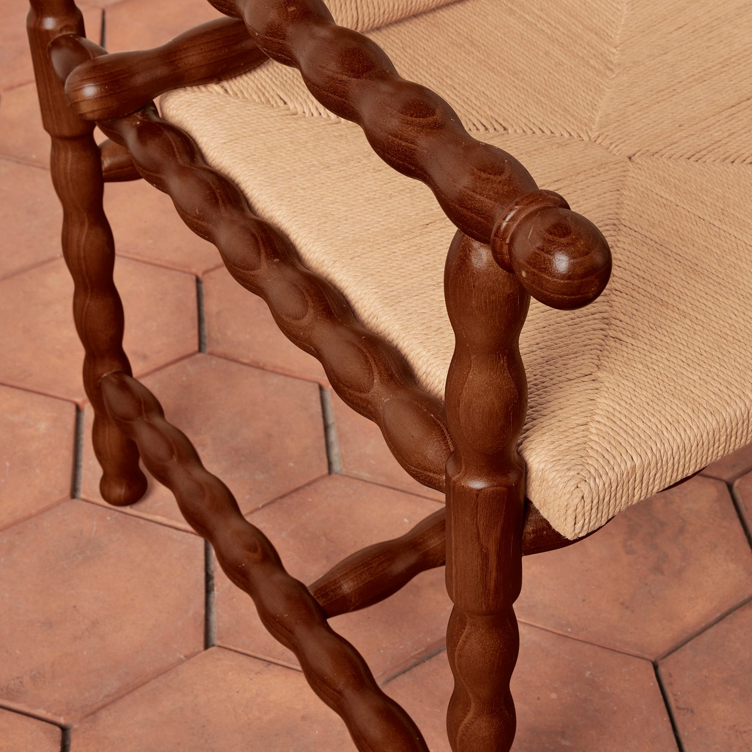 Wooden chair with twisted armrests on a stone patio- Number 8