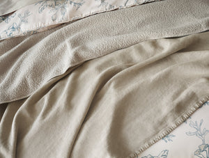 Close-up of beige textured fabric with floral patterned fabric underneath - Number 4