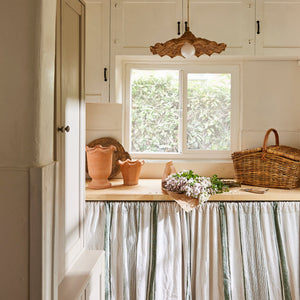 Kitchen with a window, countertop, and striped curtain. - Number 2