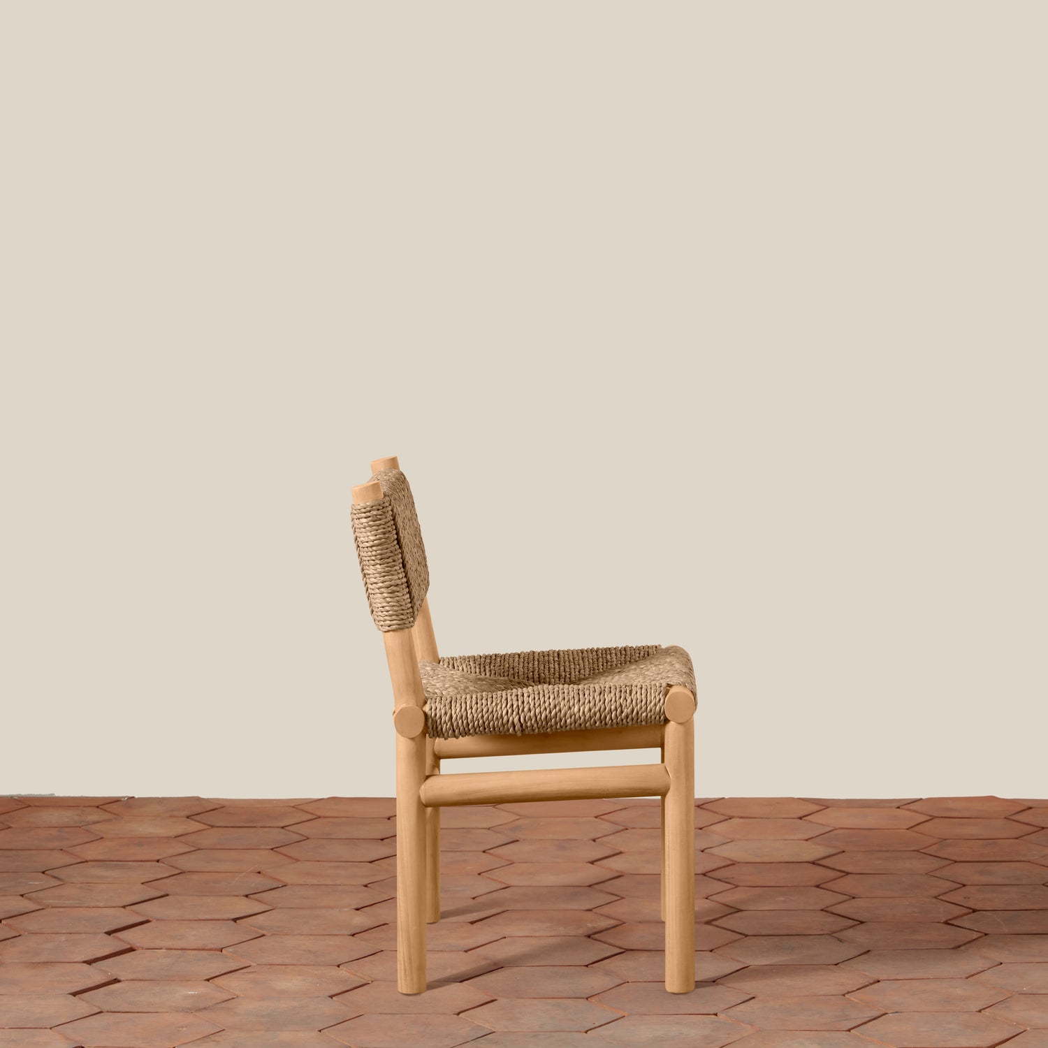 Wooden chair with woven backrest and seat on a textured floor and beige wall background- Number 6