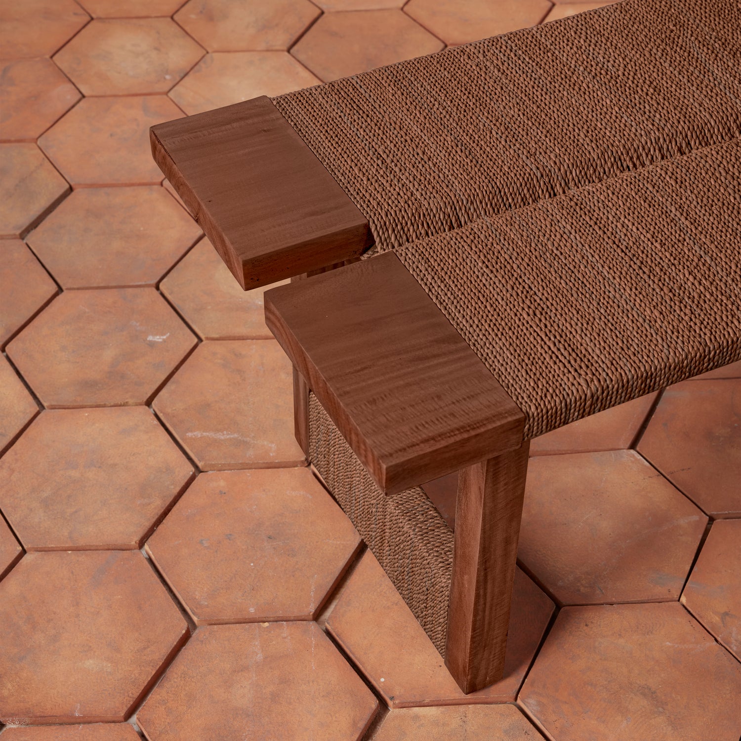 Brown woven bench on a hexagonal terracotta tile floor- Number 10