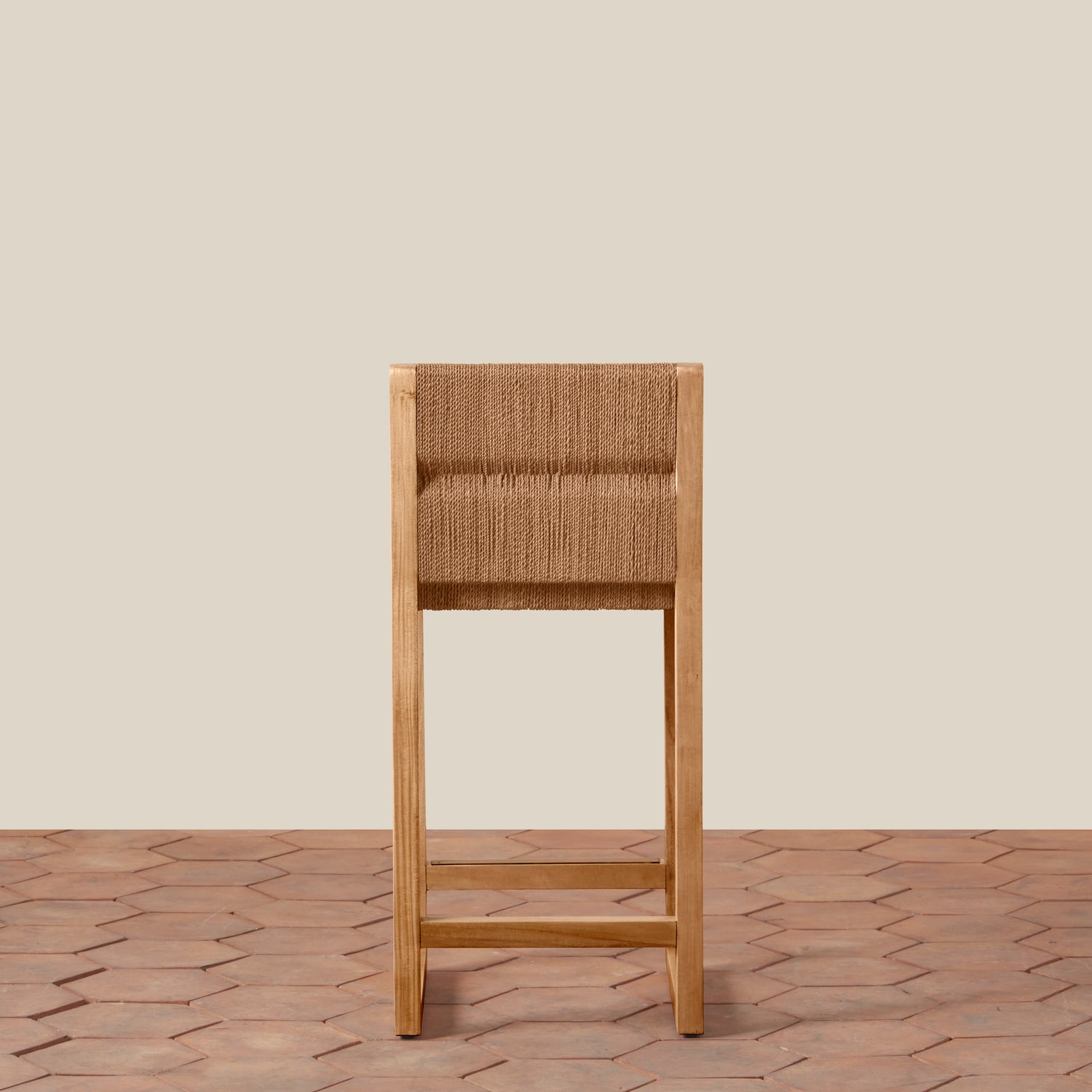 Wooden bar stool with woven seat on a wooden floor and beige wall background- Number 7