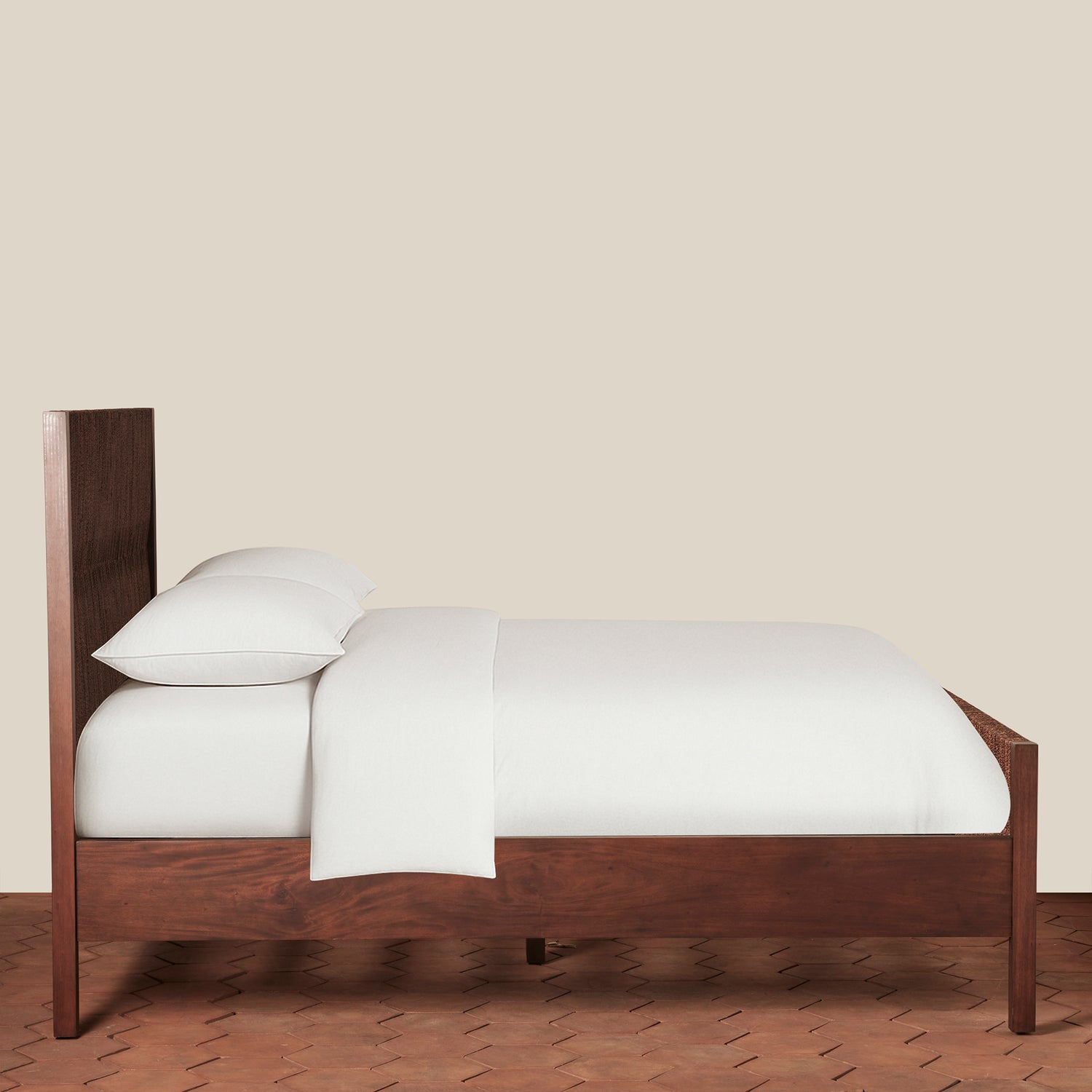 Wooden bed with white bedding against a beige wall- Number 8