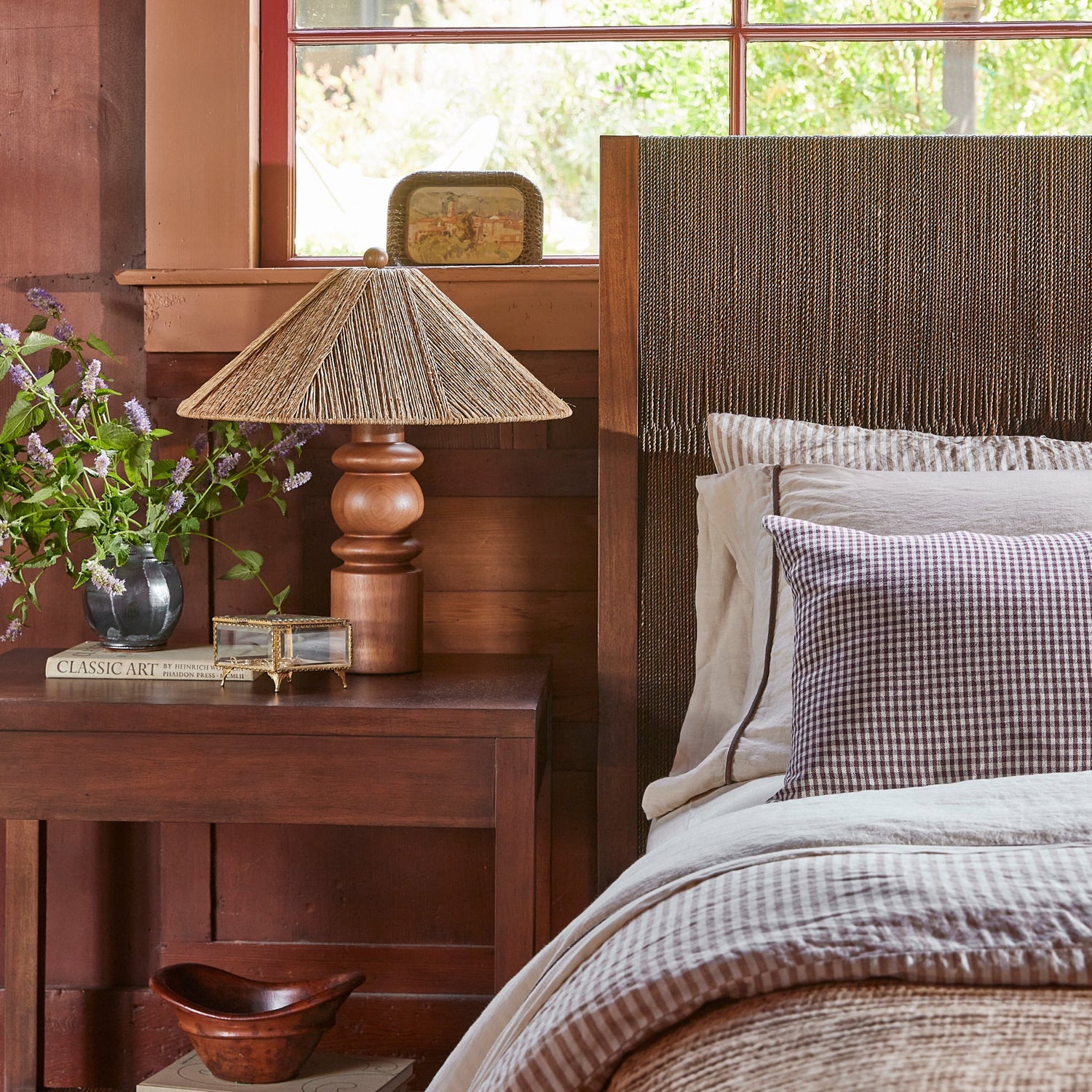 brown bed with blue and white sheets next to brown side table and lamp- Number 2