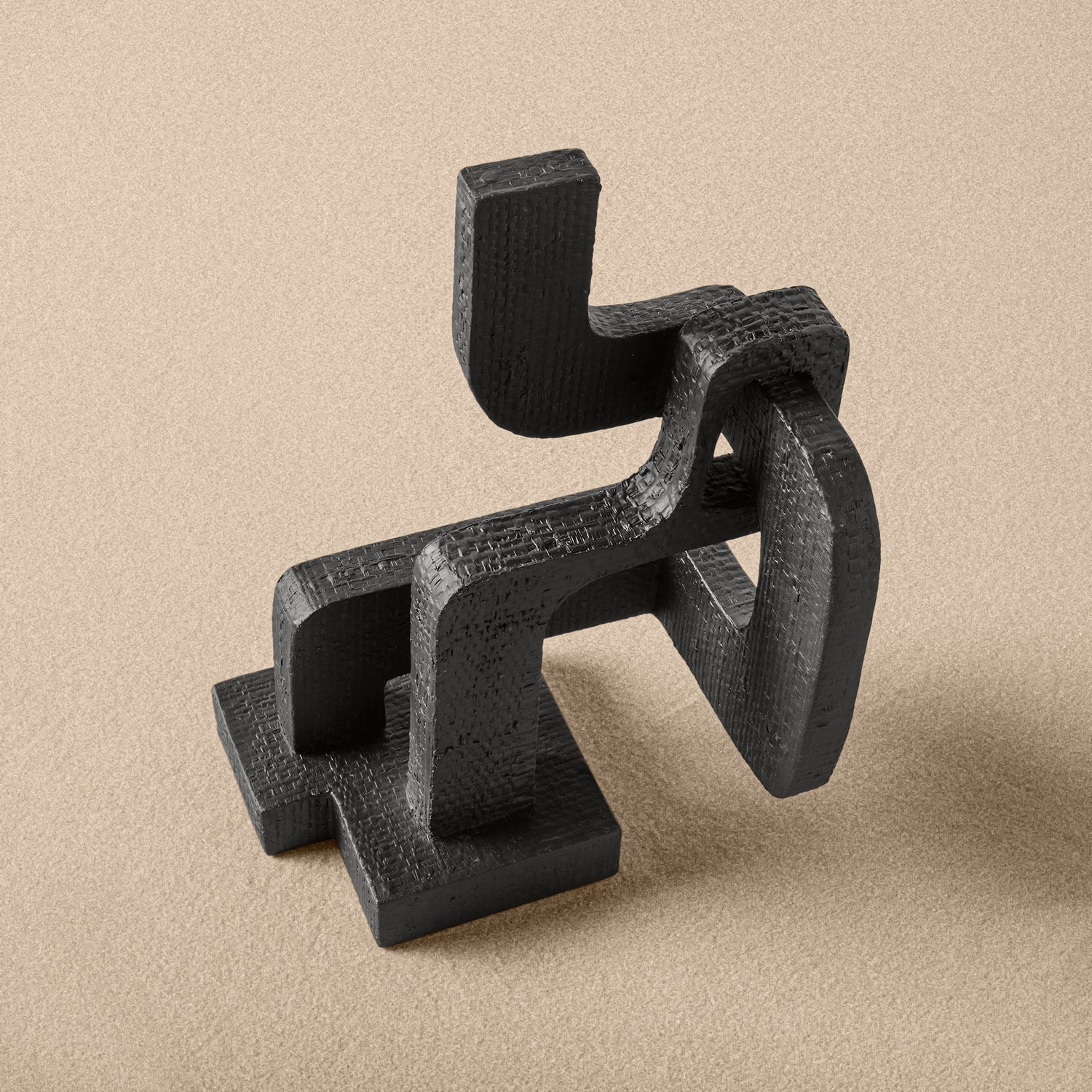 Black abstract sculpture on a beige background- Number 4