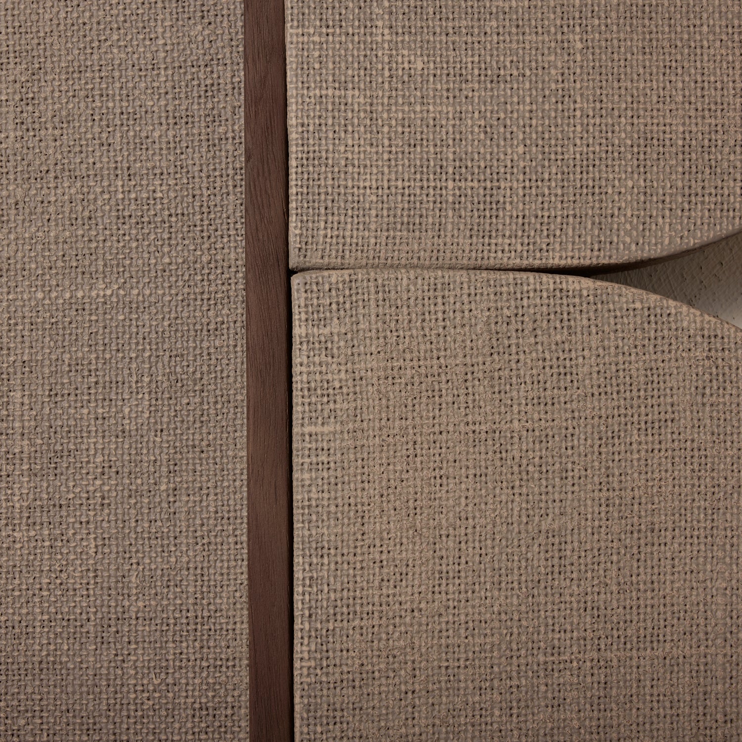 Close-up of a textured beige fabric surface with a dark brown seam.- Number 4