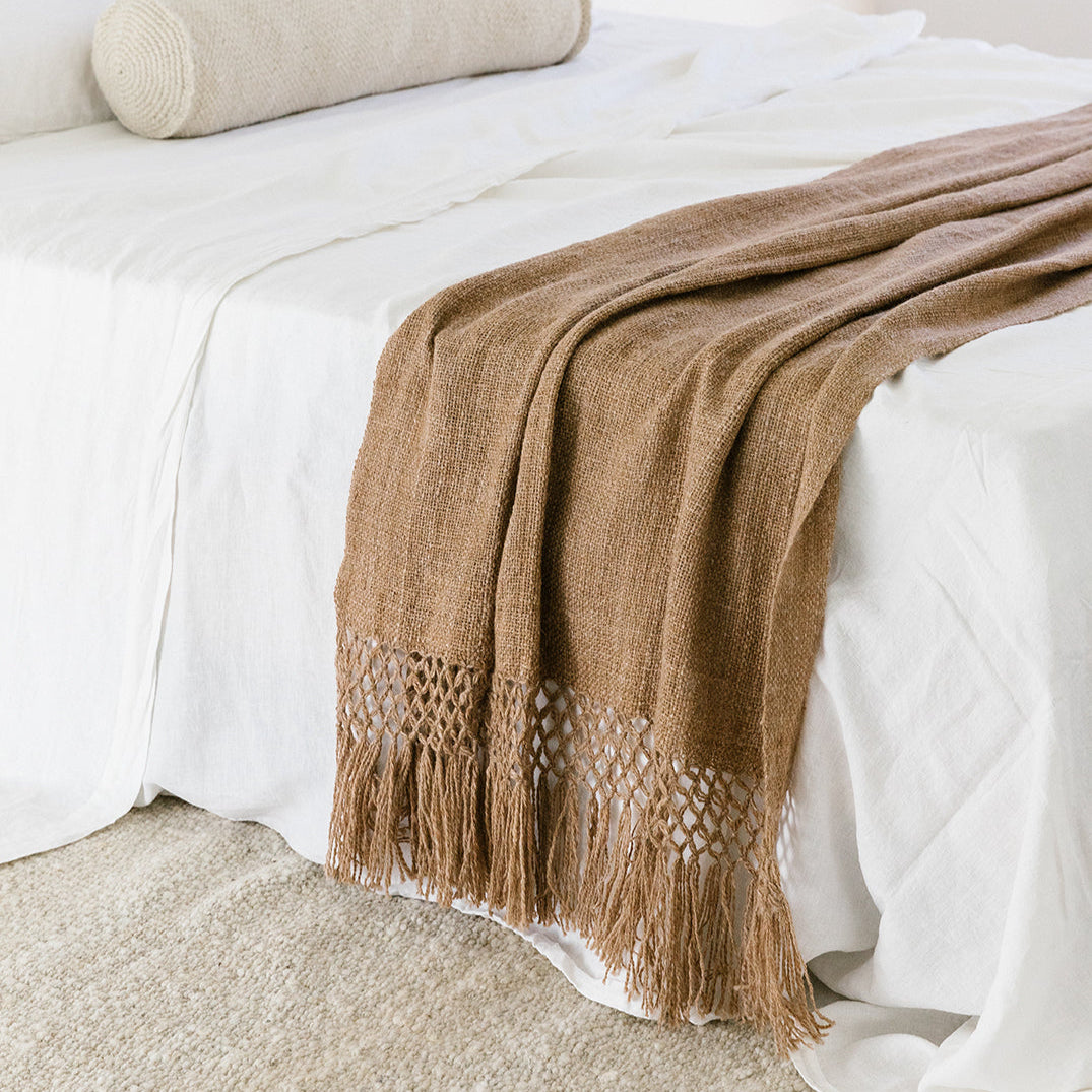 Brown blanket with fringe draped over a white bed- Number 2