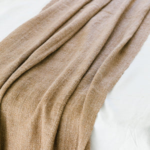 Close-up of a beige blanket draped over a white surface - Number 3