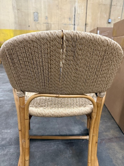 Wicker chair with a broken backrest on a concrete floor.- Number 3