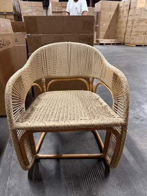 Woven chair in a warehouse setting with cardboard boxes in the background - Number 2