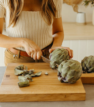 woman cutting an artichoke on cutting board - Number 3