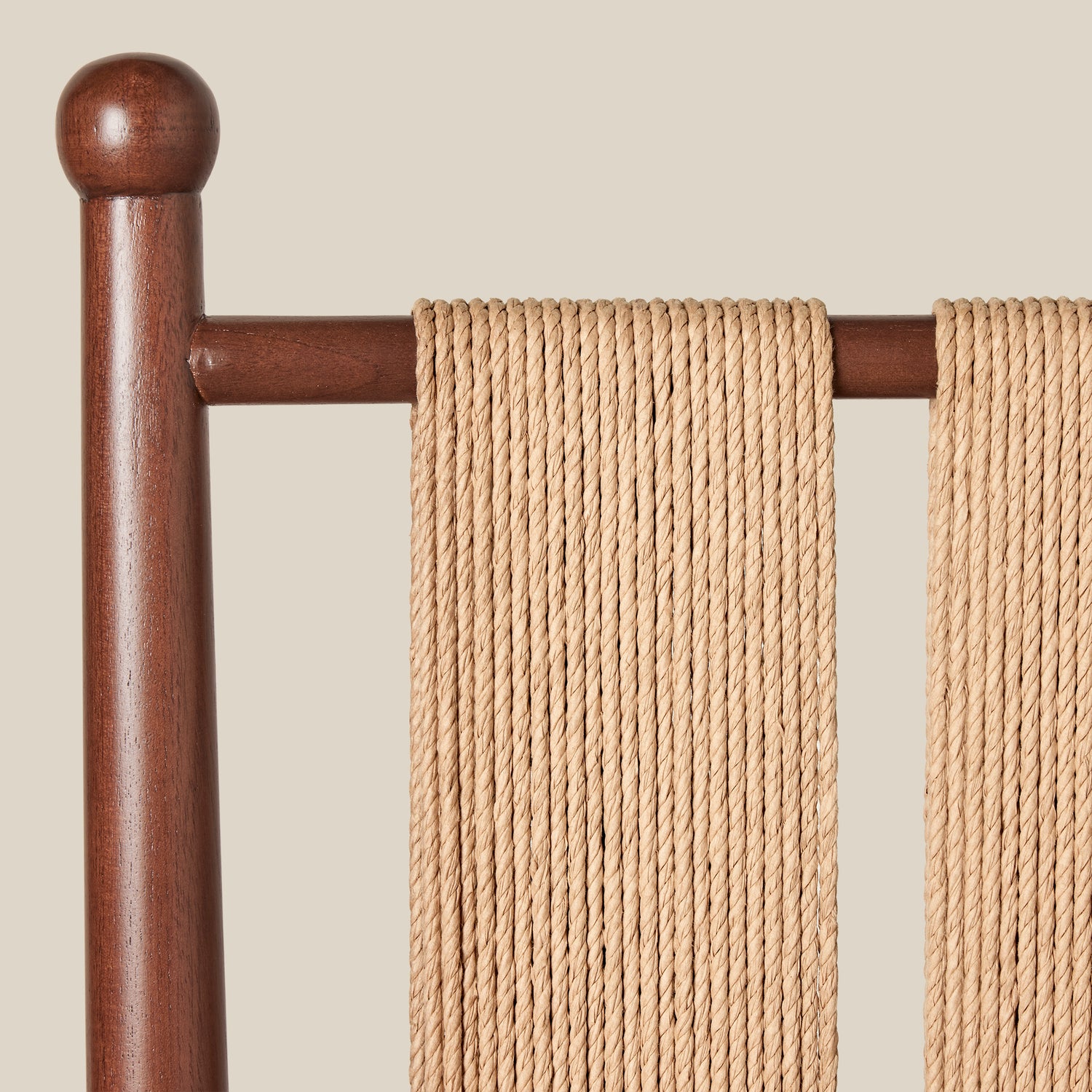 Wooden headboard with a beige blanket draped over it against a beige wall.- Number 7