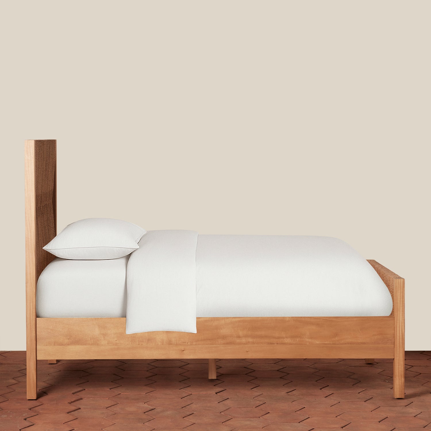 Wooden bed with white bedding against a beige wall- Number 2