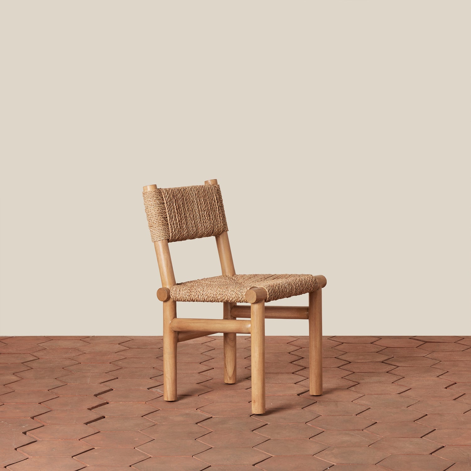 Woven chair on a wooden floor with a beige wall background- Number 1