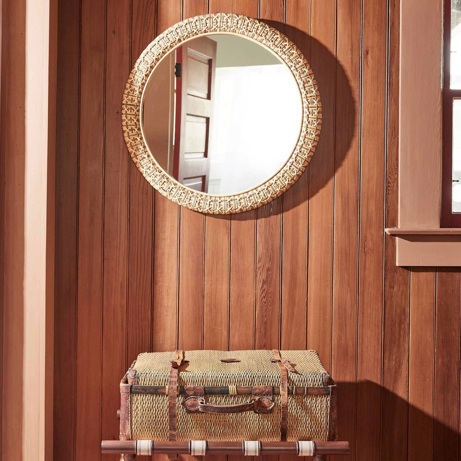 round mirrors against wood panel wall with suitcase on luggage wrack- Number 2