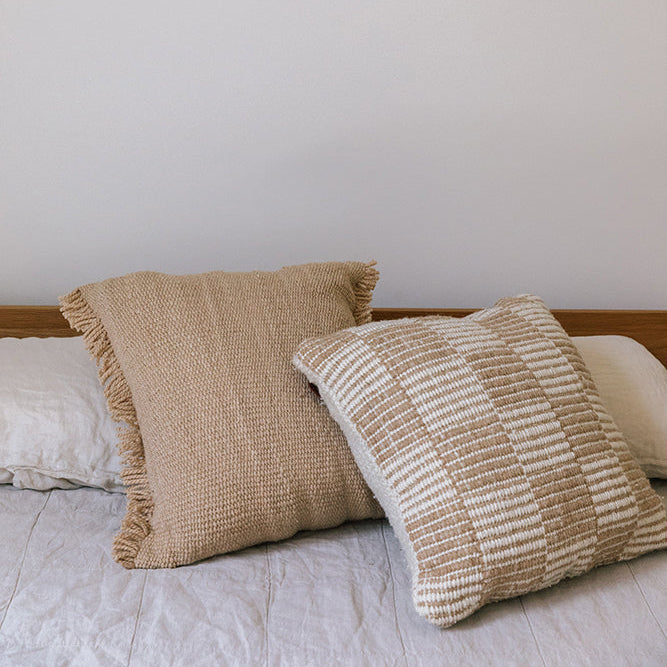 Two textured pillows on a bed with a neutral background- Number 4